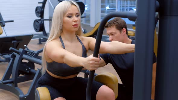 Sporty Woman with Trainer Making Exercise for Legs Booty on Training Machine