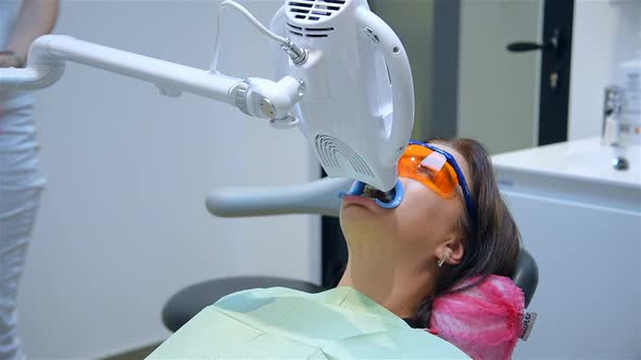 Teeth Whitening Procedure With Woman Patient At In Clinic.