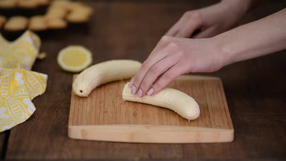 Womans Hand Chopping Banana with Kitchen Knife