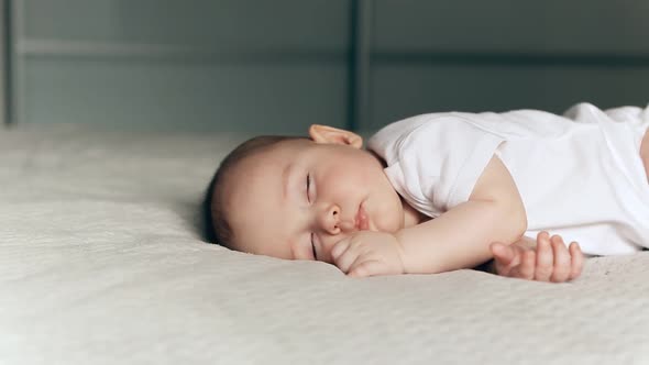 Panning Shot of Sleeping Cute Baby Boy on Gray Blanket alt
