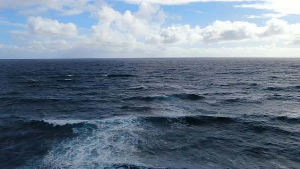 Drone majestically gliding in front of ocean waves in Hawaii alt