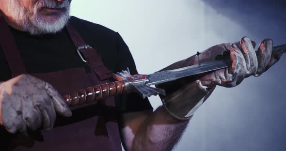 Blacksmith Looking at Sword Hilt Holding alt