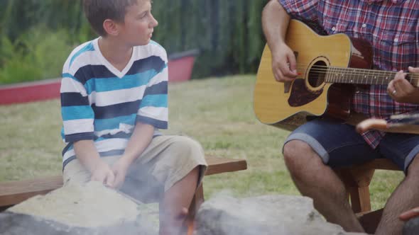 Kids at summer camp roasting marshmallows around campfire