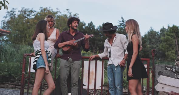 Group of friends playing ukulele and having a great time alt