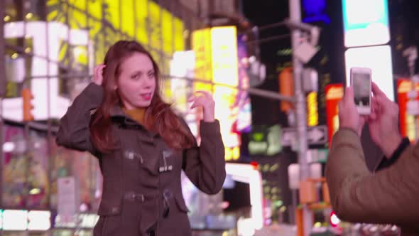 Couple taking cell phone photos in Times Square, New York City