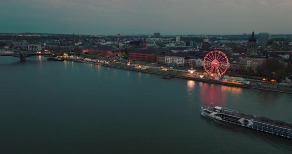 Mainz summer night with city lights and ships on the Rhein river in front of orange sky by a crossin alt