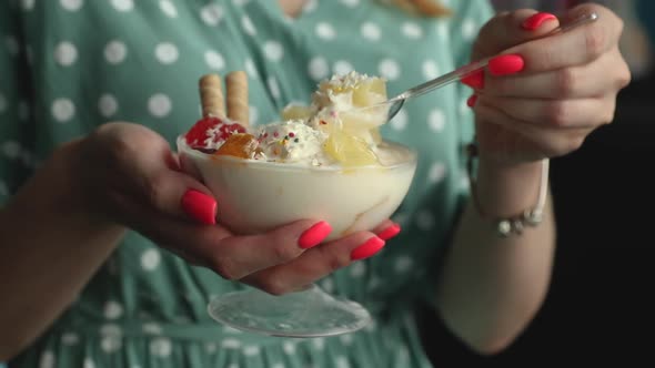 girl in green polka dot dress eating bowl with sweet ice cream