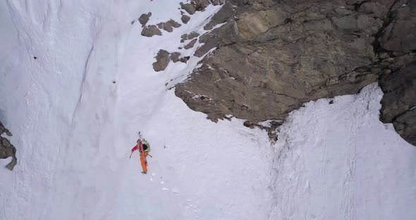 Aerial drone view of a mountain climber climbing up with crampons in the snow. alt