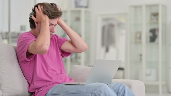 Upset Casual Young Man Reacting To Loss on Laptop at Home  alt