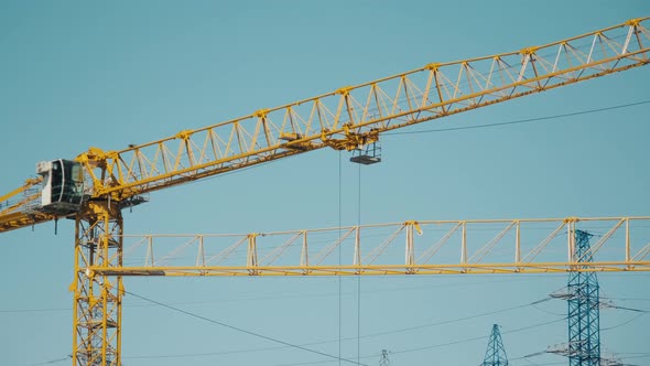 Yellow Boom of the Crane Turns From Right to Left Against the Blue Sky