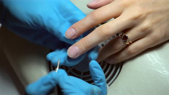 Close up footage of professional nail file drill in action finger nail treatment	 alt