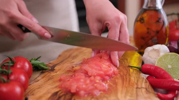 Woman Cutting Peeled Tomato Using Kitchen Knife alt