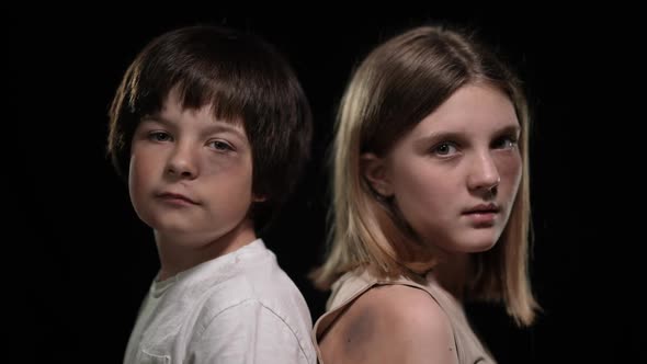 Closeup Bruised Faces of Little Boy and Teenage Girl Turning Looking at Camera alt