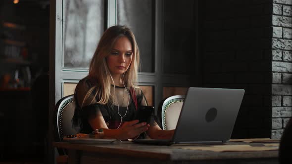 Freelancer Woman Working with a Laptop in a Coffee Shop, Close Up View alt