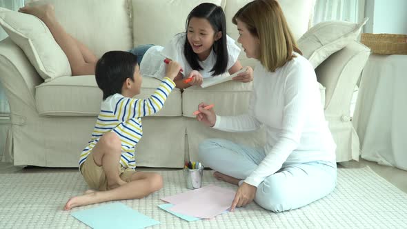 Asian Family Drawing Together In Living Room alt