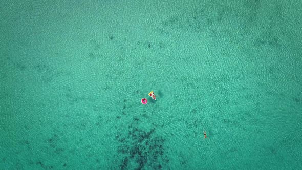 Aerial view of two young girls swimming and playing in sea with inflatables. alt