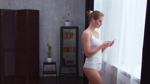 Young  girl is standing in front of the window alt