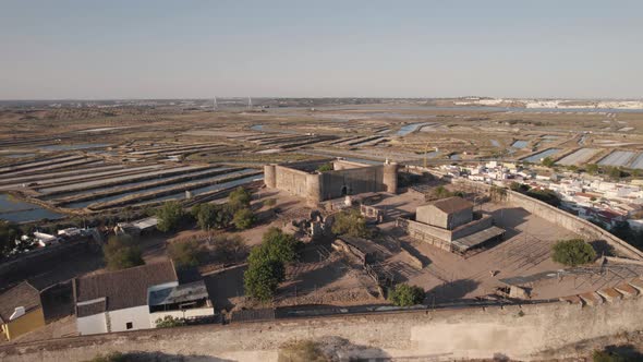 Castro Marim Castle aerial pullback.Fortified structure on hilltop overlooking the town alt