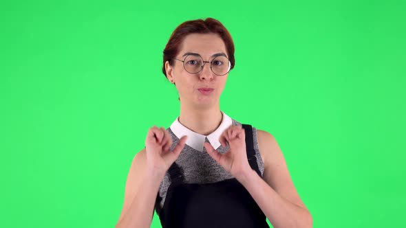 Portrait of Funny Girl in Round Glasses Is Blowing Kiss. Green Screen alt