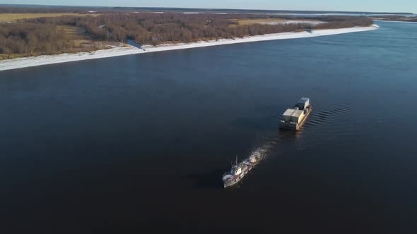 Barge floating on a wide river alt