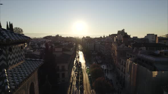 Sunset over city of Granada, flight past bell tower of Mudejar church