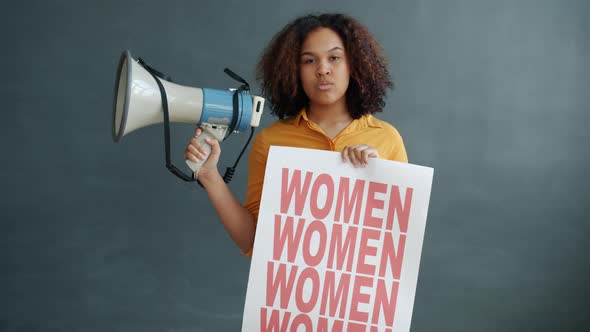Portrait of African American Activist Holding Loudspeaker and Women Empowerment Banner alt