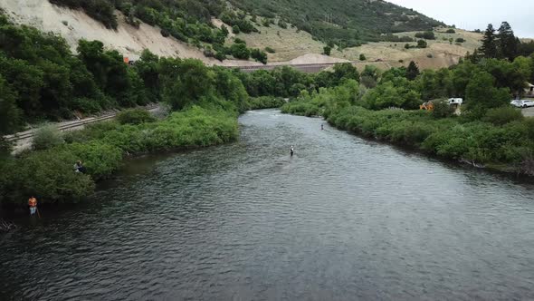 Drone Shot approaching a man Fly Fishing in the Provo River in the Mountains of Utah. alt