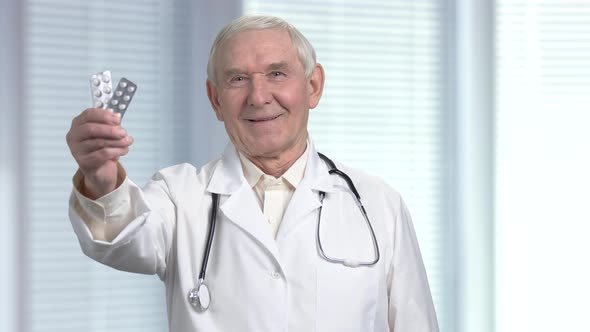 Senior Doctor Prescribing Pills in Strip. alt