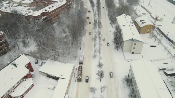 Cars on a City Straight Road Covered with Thick White Snow After a Blizzard alt