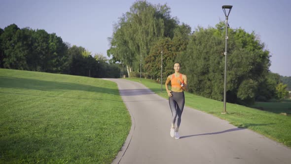 Healthy Woman Jogging In City Park