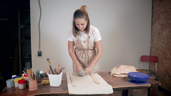Young Woman Is Cutting Clay Ball By Wire, Splitting It on Two Part and Kneading