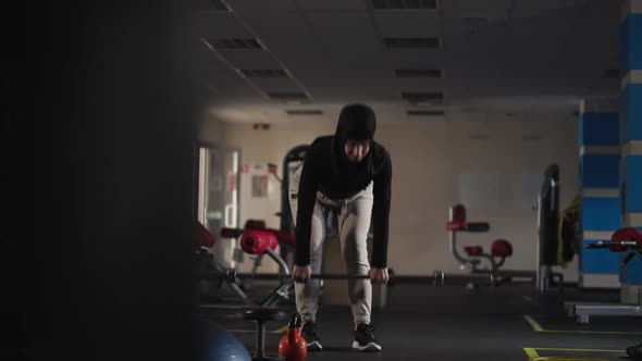 Front View Wide Shot of Concentrated Woman in Hijab Bending Forward Holding Barbell with Boxing alt