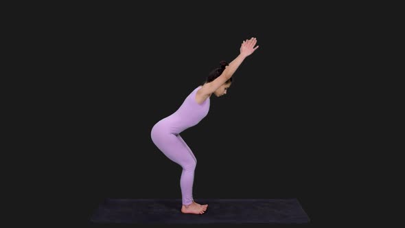 Young Fit Woman Doing Revolved Chair Pose While Practicing Yoga, Alpha in