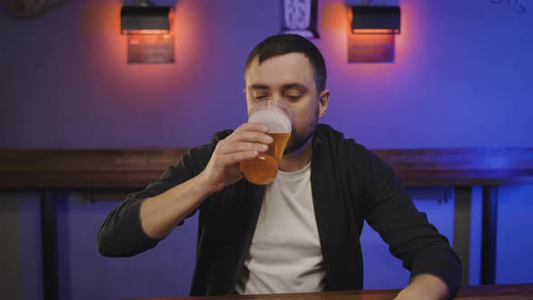 Portrait of Man in Pub with Glass of Beer in Hand at Bar Counter