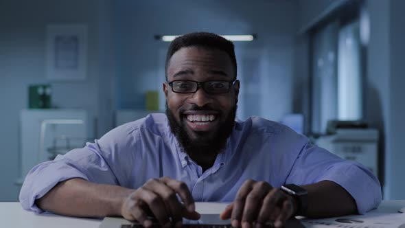 Excited AfricanAmerican Entrepreneur Looking at Computer Screen and Smiling in Office alt