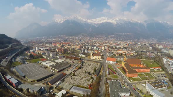 Active Traffic on Streets of Megalopolis, Cloudy Sky Over Snowy Rocky Mountains alt