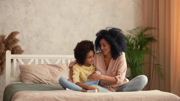African American Woman and Little Girl are Hugging Each Other and Have Fun Talking alt