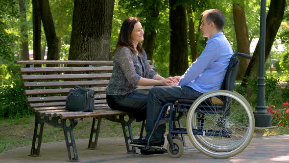 Man on Wheelchair Talking with His Wife
