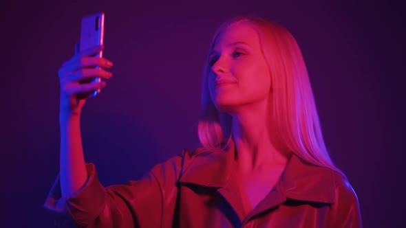 Stylish Young Woman Dancing in a Nightclub and Talking By Video Call Using the Phone
