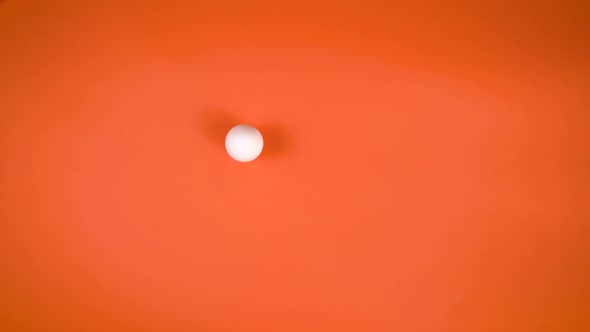 White Egg Spinning On Orange Background