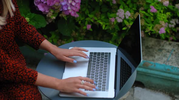Young Businesswoman Working with Laptop and Typing at Table Outdoors on Summer Day Rbbro alt