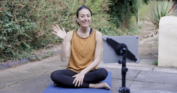 Yoga instructor teaching online class in her garden alt