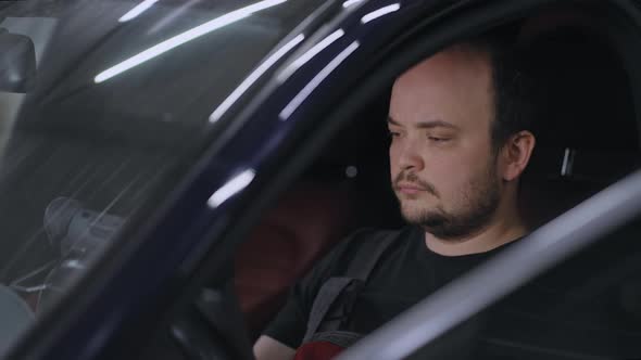 Male Mechanic Uses a Tablet Computer with an Augmented Reality Diagnostics Software alt