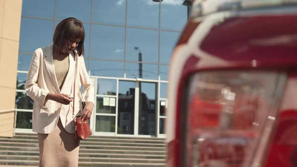 African Woman Locking Her Car and Going Away alt