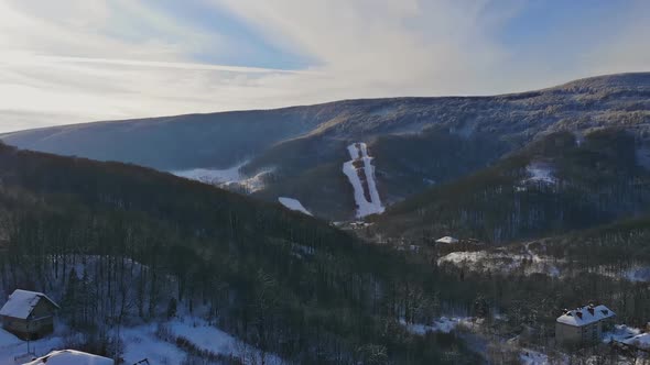 Rural landscape in the mountains in winter. Snow-covered houses in the snow from alt