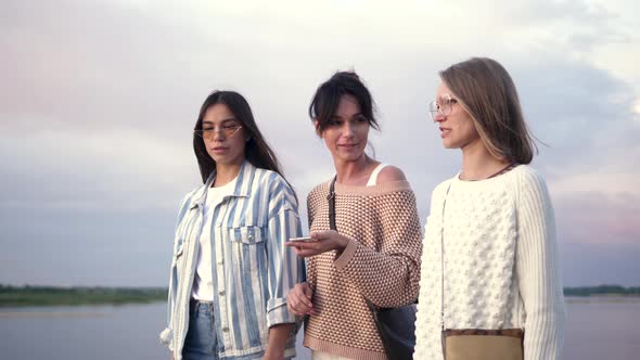 Woman Using a Smartphone Voice Recognition Function Online While Walking with Her Friends alt