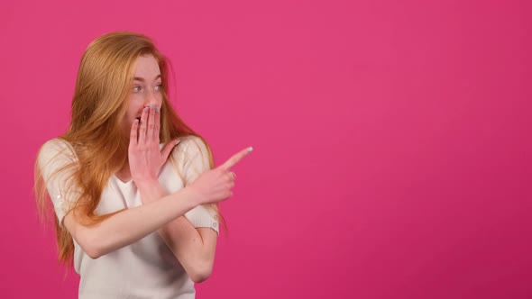 Woman Shocked By Something Covers Her Mouth with Her Hand and Points to the Right alt