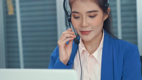 Businesswoman Wearing Headset Working Actively in Office alt
