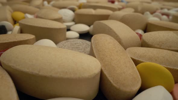 Pills in Medical Lab Moving Slowly Over Them in Close Up View