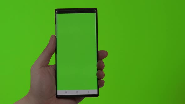 Smartphone screen. Smart phone isolated on color background. Green screen chroma key technique. Man